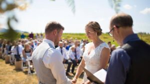 Couple getting married by priest during sunny day