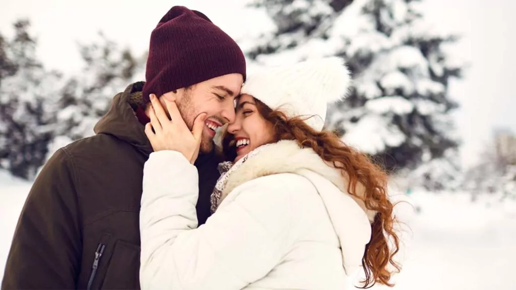 Happy couple embracing in a snowy winter scene.