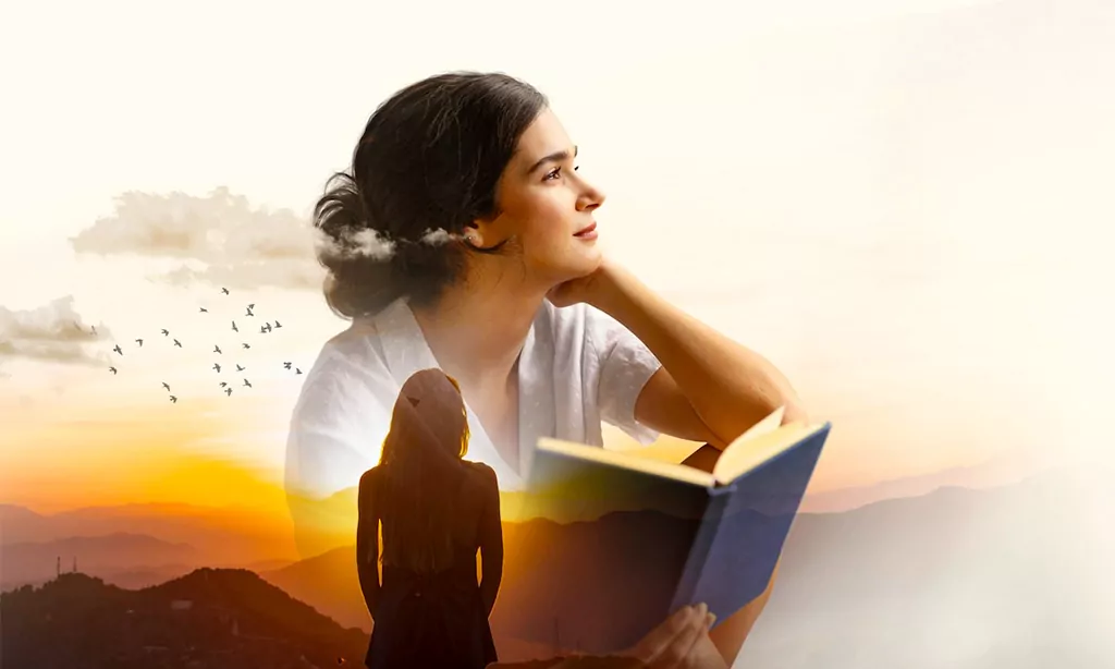 A woman gazing thoughtfully while holding an open book