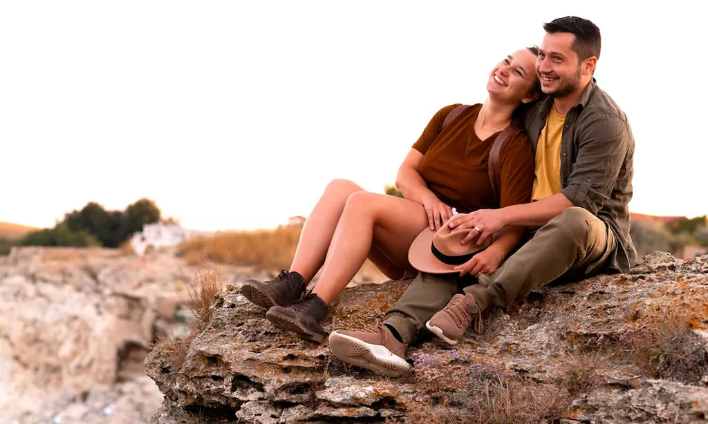 Happy Couple Relaxing Outdoors on Rocky Cliff